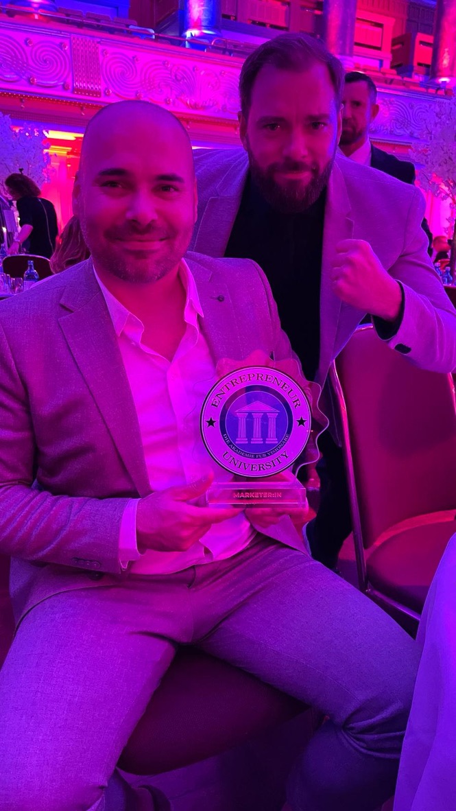Manuel Lutter mit der Marketer of the Year 2024 Trophäe der Entrepreneur University